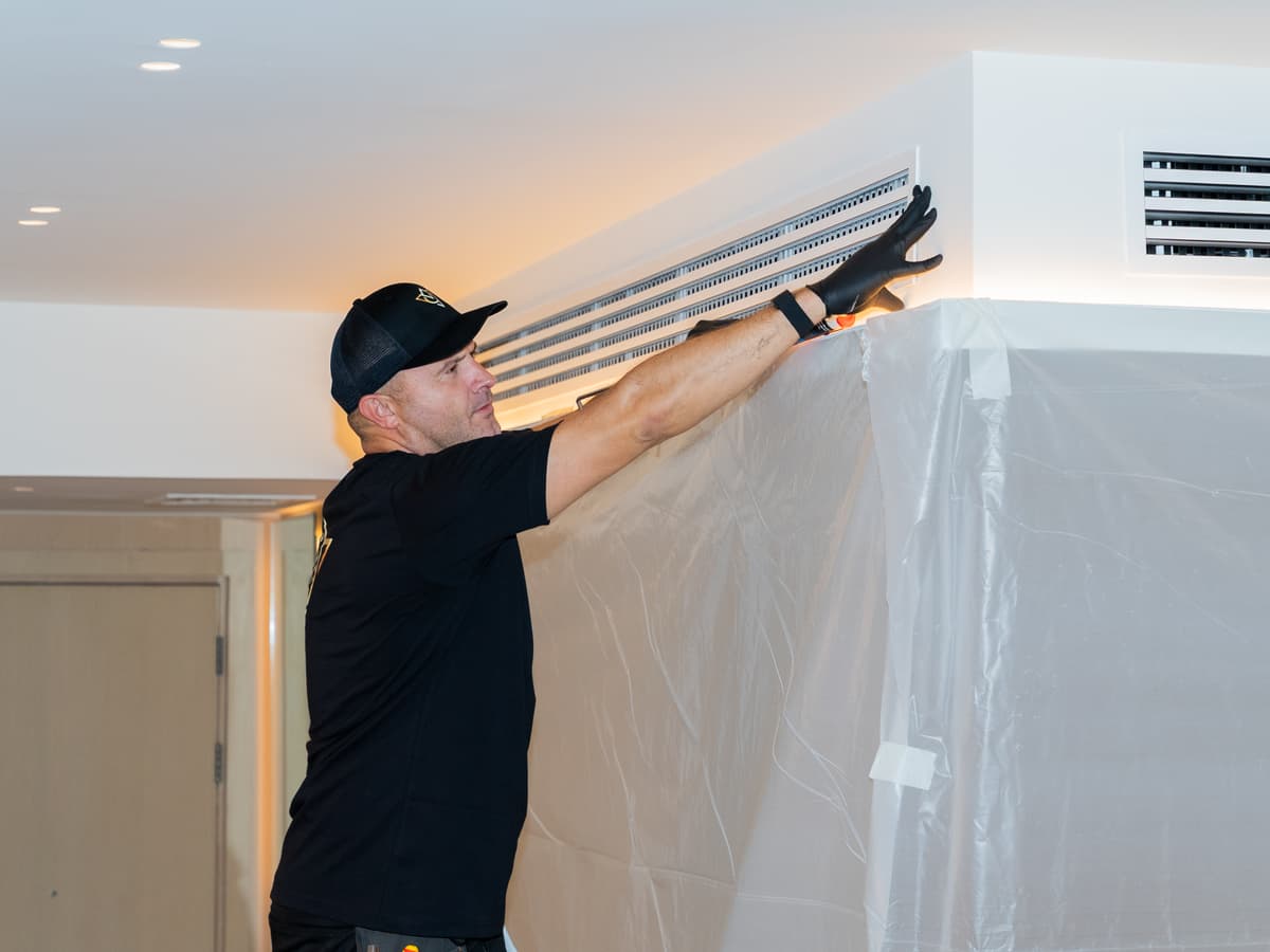 Vita Technical engineer inspecting AC vent grille